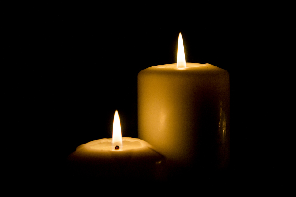 Lit candle on black background